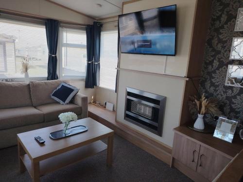 a living room with a couch and a fireplace at The Victory Vermont in Leysdown-on-Sea