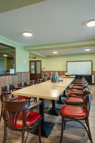 a classroom with tables and chairs and a chalkboard at Pensiunea La Bella Vista in Poiana Negrii