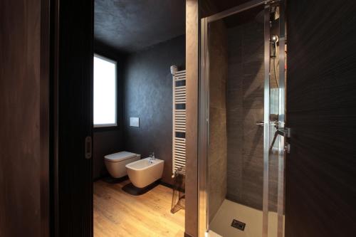 a bathroom with a toilet and a glass shower at Crimea Wine Hotel in Chiavenna