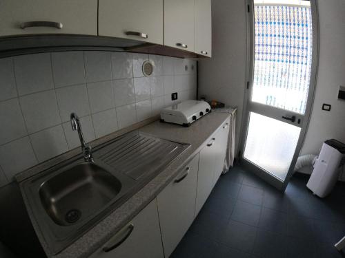 a small kitchen with a sink and a window at Vento a poppa in Porto Palo