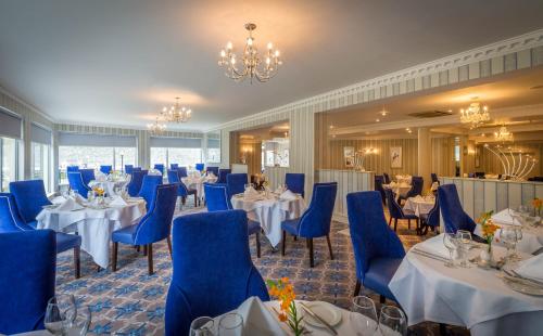 Kilkenny River Court Hotel في كيلكيني: قاعة احتفالات بطاولات وكراسي وثريا