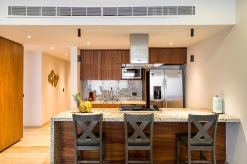 a kitchen with a large island with bar stools at Family Friendly APT 17 ocean view, 3BR, 6 pax in San José del Cabo