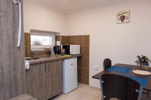 a kitchen with a sink and a counter top at Dorottya Vendégház in Hódmezővásárhely