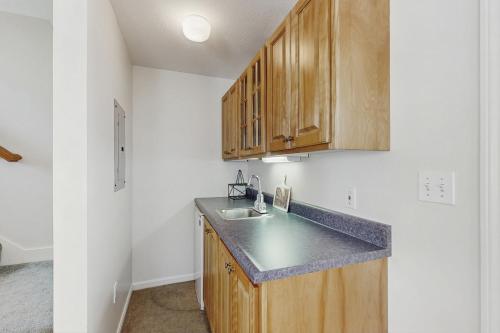 a kitchen with a sink and wooden cabinets at Y Go By in Kennebunkport