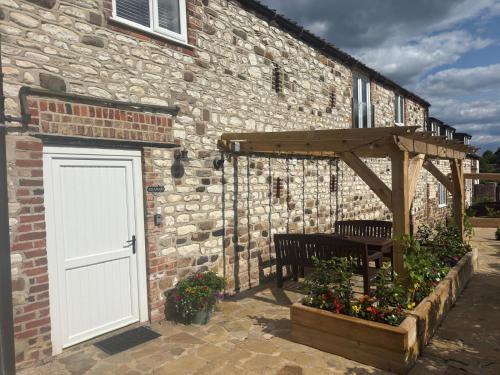 a stone building with a white door and a bench at The Granary in Bridlington