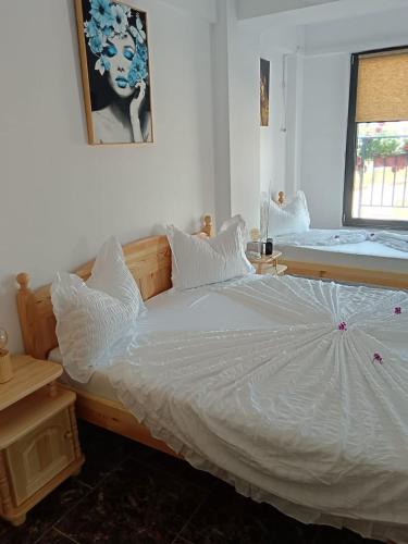 a bedroom with a white bed with an umbrella on it at Seven Apartament in Mangalia