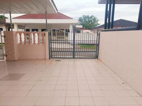 a black gate in front of a house at Cream Roof Homestay in Gua Sai