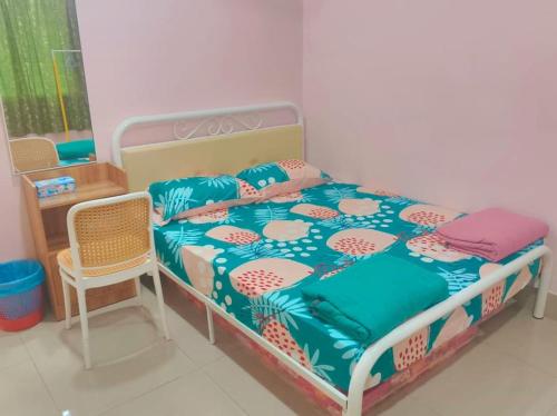 a bedroom with a bed and a chair at Cream Roof Homestay in Gua Sai