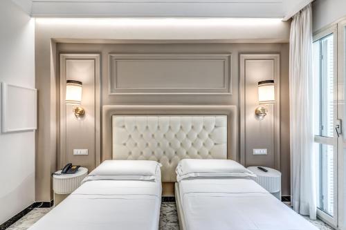 two beds in a room with a wall at Hotel Castel Vecchio in Castel Gandolfo