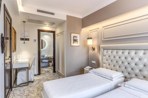 a hotel room with two beds and a bathroom at Hotel Castel Vecchio in Castel Gandolfo