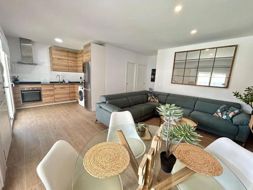 Una sala de estar con un sofá azul y una mesa. en Chalet Empul Los Pinares, en Chiclana de la Frontera