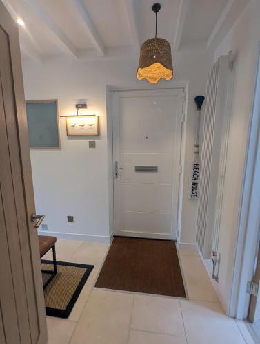 a hallway with a white door and a brown rug at Saltwater Lodge - Air Conditioned 75yrd to the sea in Seaview