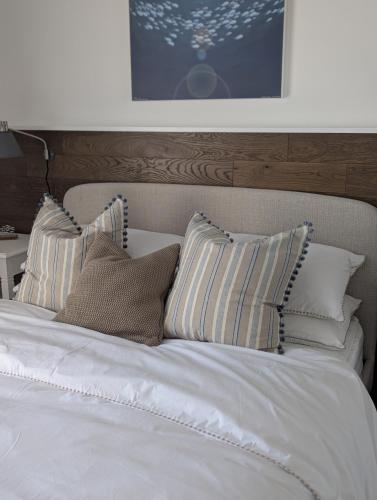 a bed with white sheets and pillows on it at Saltwater Lodge - Air Conditioned 75yrd to the sea in Seaview