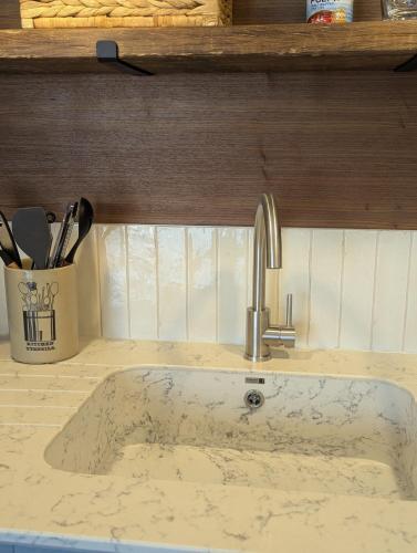 a kitchen sink with a faucet on a counter at Saltwater Lodge - Air Conditioned 75yrd to the sea in Seaview