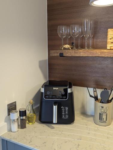 a kitchen counter with a coffee maker and wine glasses at Saltwater Lodge - Air Conditioned 75yrd to the sea in Seaview