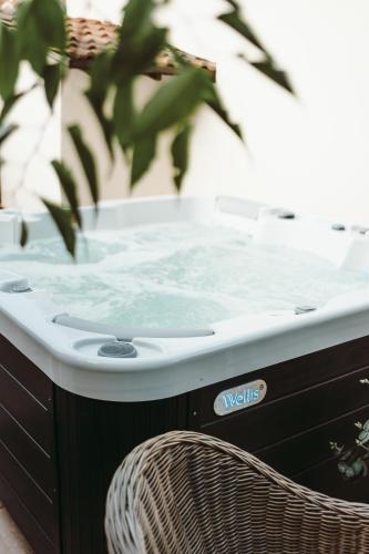 a hot tub sitting next to a chair at História Présház boutique Nagyréde in Gyöngyös