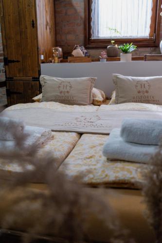 two large beds in a room with a window at História Présház boutique Nagyréde in Gyöngyös