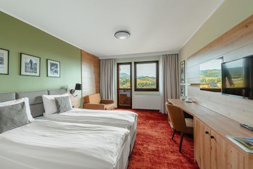 a hotel room with a large bed and a desk at Pensiunea La Bella Vista in Poiana Negrii