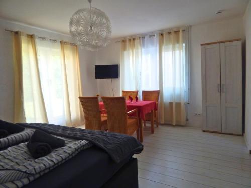 a bedroom with a red table and chairs and a dining room at Hotel Neptuns Ankerplatz in Cuxhaven