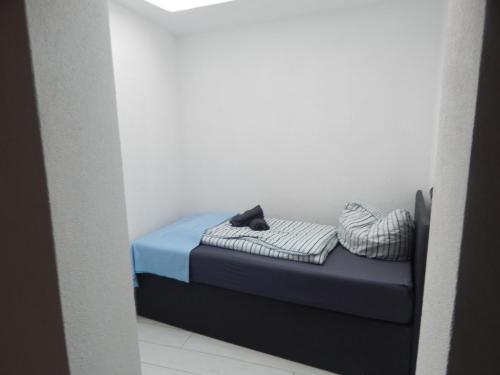 a small bed with two pillows in a room at Hotel Neptuns Ankerplatz in Cuxhaven