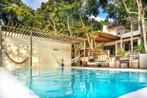 a swimming pool in front of a house at Suítes na Vila Mansinha - perto do quadrado in Trancoso