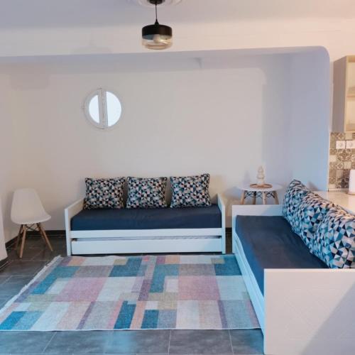 a room with two beds and a rug at L'appartement Bleu in Bejaïa