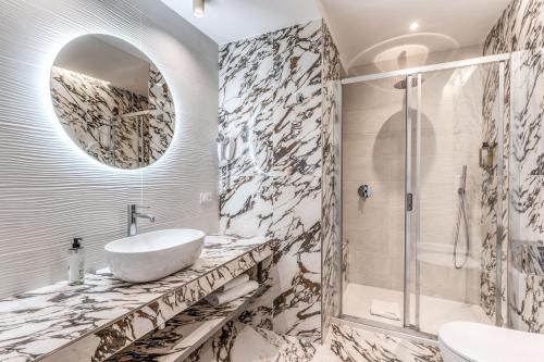 łazienka z umywalką i lustrem w obiekcie Hotel Castel Vecchio w mieście Castel Gandolfo