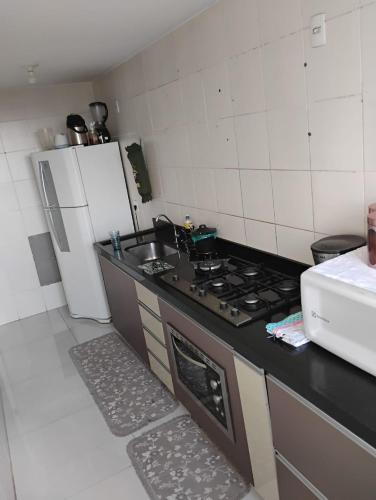 a kitchen with a stove and a sink and a refrigerator at Apartamento privativo com garagem in Brasilia