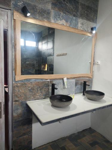 a bathroom with two sinks on a counter with a mirror at Residence Gentil in Saint Gabriel