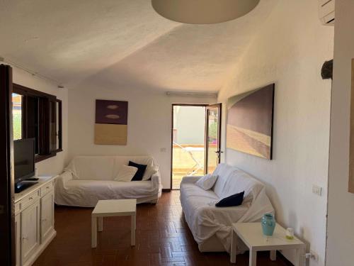 a living room with two white couches and a tv at Sardegna Beach Cala Reale in Santa Marinella