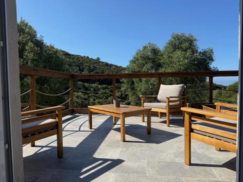 un patio con bancos, una mesa y una silla en Les OULIVASTRES, en Hyères