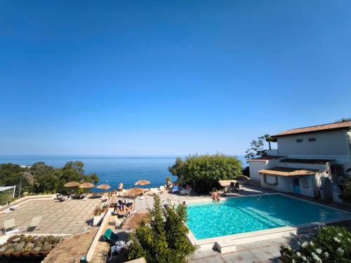 a swimming pool with a view of the ocean at Residence Terra Rossa Taormina in Taormina