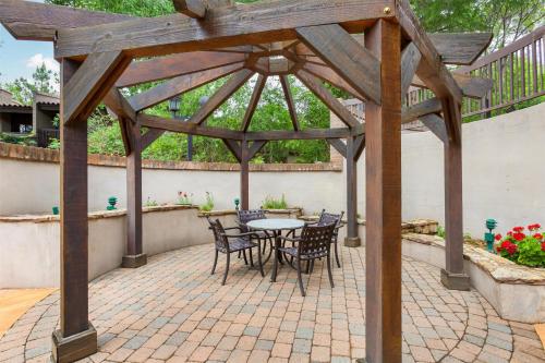 a wooden pergola with a table and chairs on a patio at Best Western Plus Arroyo Roble Hotel & Creekside Villas in Sedona