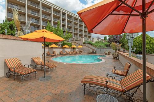 a pool with chairs and umbrellas in front of a hotel at Best Western Plus Arroyo Roble Hotel & Creekside Villas in Sedona