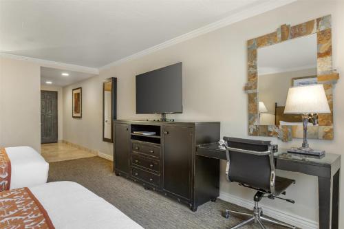 a hotel room with a desk and a television at Best Western Plus Arroyo Roble Hotel & Creekside Villas in Sedona