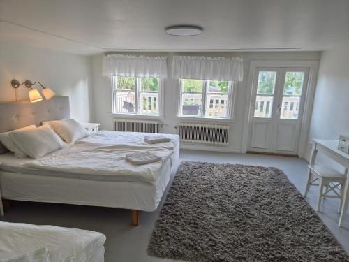 a bedroom with a bed and a chair and windows at Påryds Bed & Breakfast in Påryd