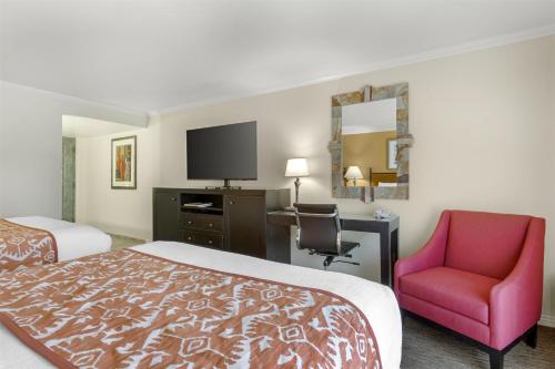 a hotel room with a bed and a chair and a television at Best Western Plus Arroyo Roble Hotel & Creekside Villas in Sedona