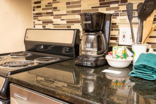 a kitchen counter with a stove and a coffee maker at Hi Country Haus Unit 0406 in Winter Park