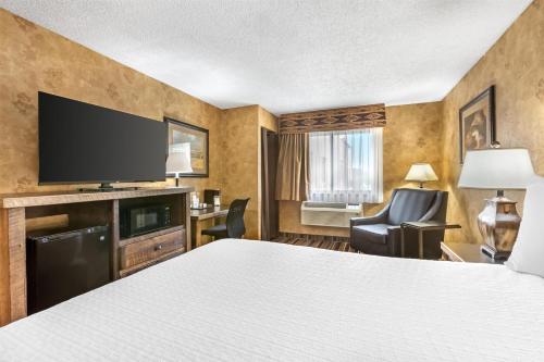 a hotel room with a bed and a flat screen tv at Best Western Plus Inn of Santa Fe in Santa Fe