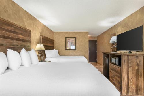 a hotel room with two beds and a flat screen tv at Best Western Plus Inn of Santa Fe in Santa Fe