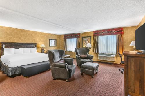 a hotel room with a bed and two chairs at Best Western Plus Inn of Santa Fe in Santa Fe