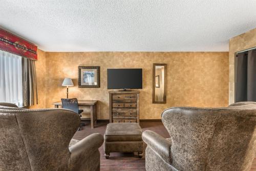 a hotel room with chairs and a flat screen tv at Best Western Plus Inn of Santa Fe in Santa Fe