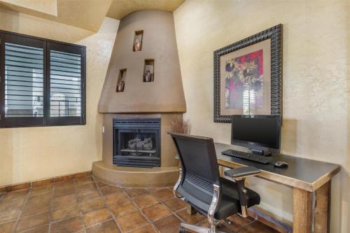 a room with a desk with a computer and a chair at Best Western Plus Inn of Santa Fe in Santa Fe