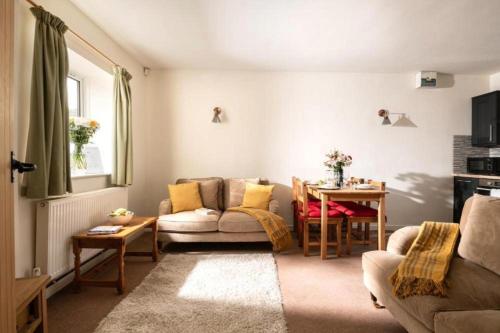 a living room with a couch and a table at Martinmas Cottage in Flamborough
