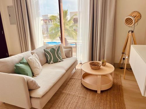 a living room with a couch and a table at Dream Apartment - Near Beach with Pool View & WiFi in Salalah