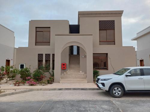 a white car parked in front of a house at Dream Apartment - Near Beach with Pool View & WiFi in Salalah