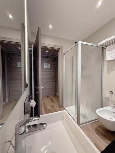 a bathroom with a white tub and a sink at Best Western Plus Borgolecco Hotel in Arcore