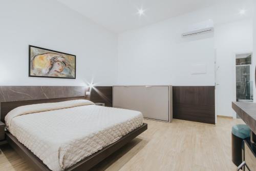a bedroom with a large bed and a white wall at Dimora Favia in Bari