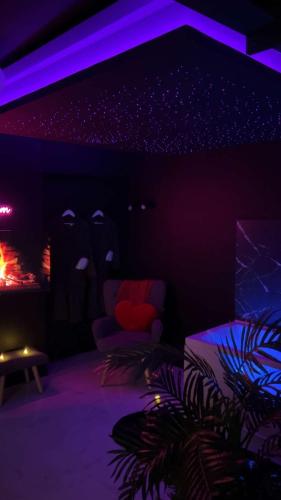 a dark room with a chair and a fire place at Appartement de luxe avec jacuzzi dans le centre de Macon in Mâcon