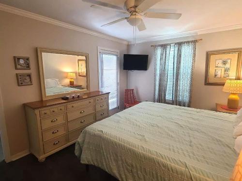 a bedroom with a bed and a dresser with a mirror at Beautiful 3 Bedroom BEACHFRONT Condo (F3) - Sleeps 10 in Gulf Shores